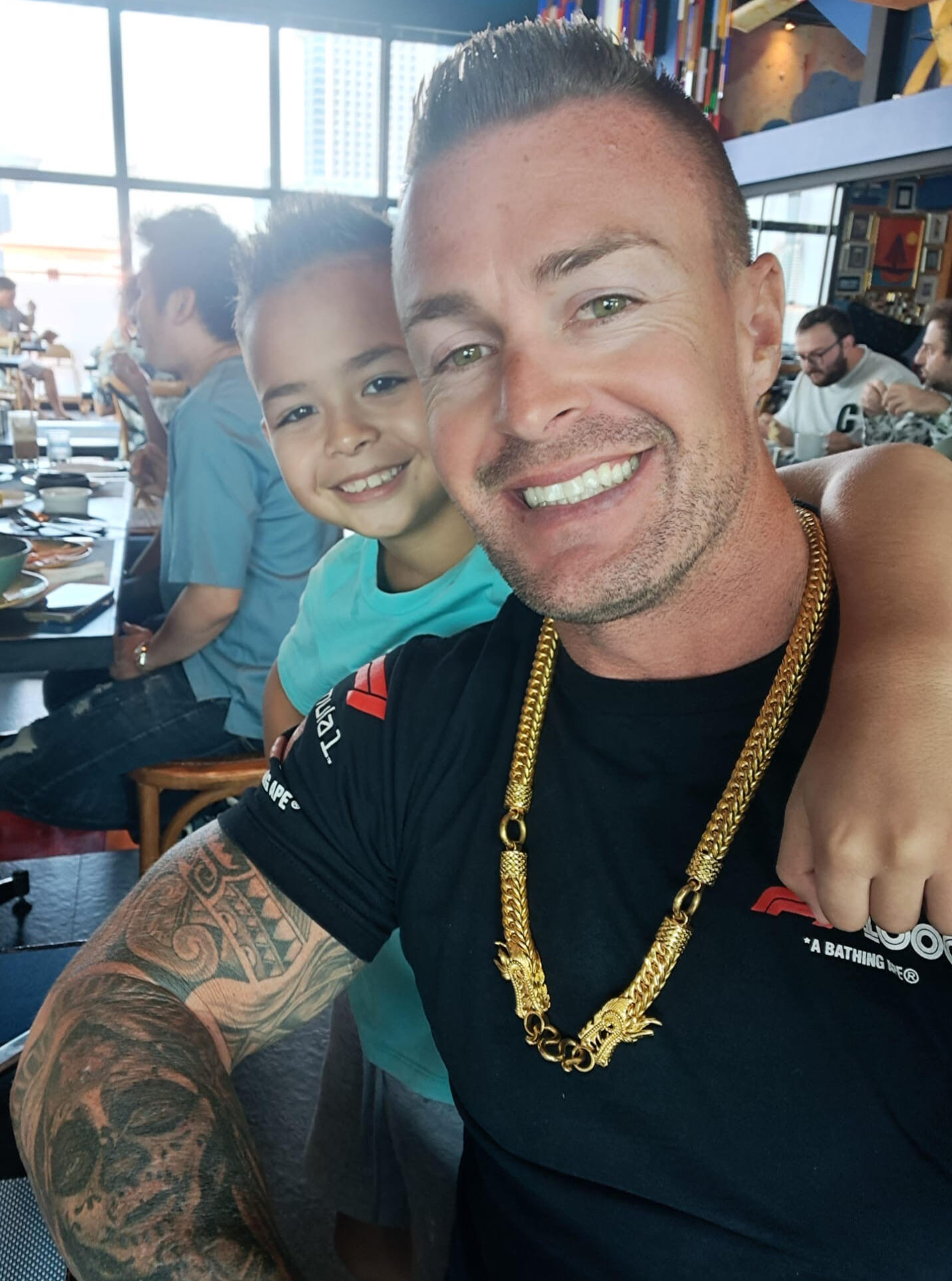 Smiling dad and son reading The Tween Playbook at the restaurant